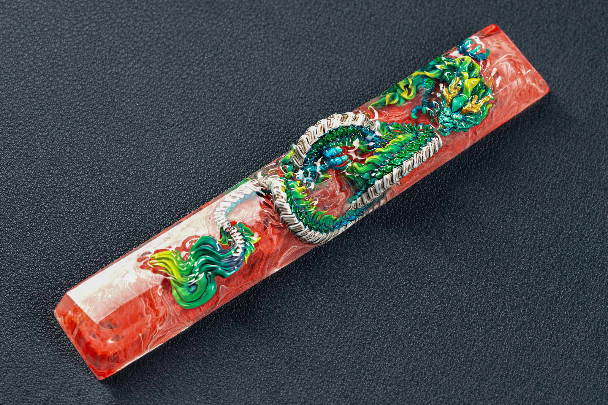 Colorful dragon-themed resin pen on dark background.