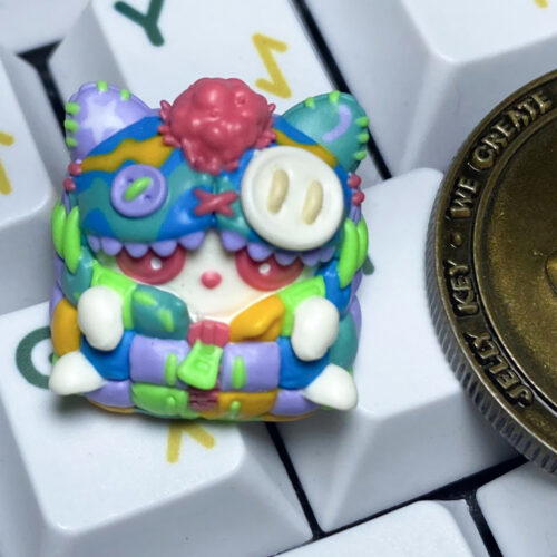 Colorful miniature monster figurine beside a coin.